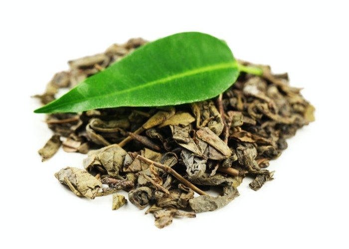 Dried green tea leaves with fresh one on top